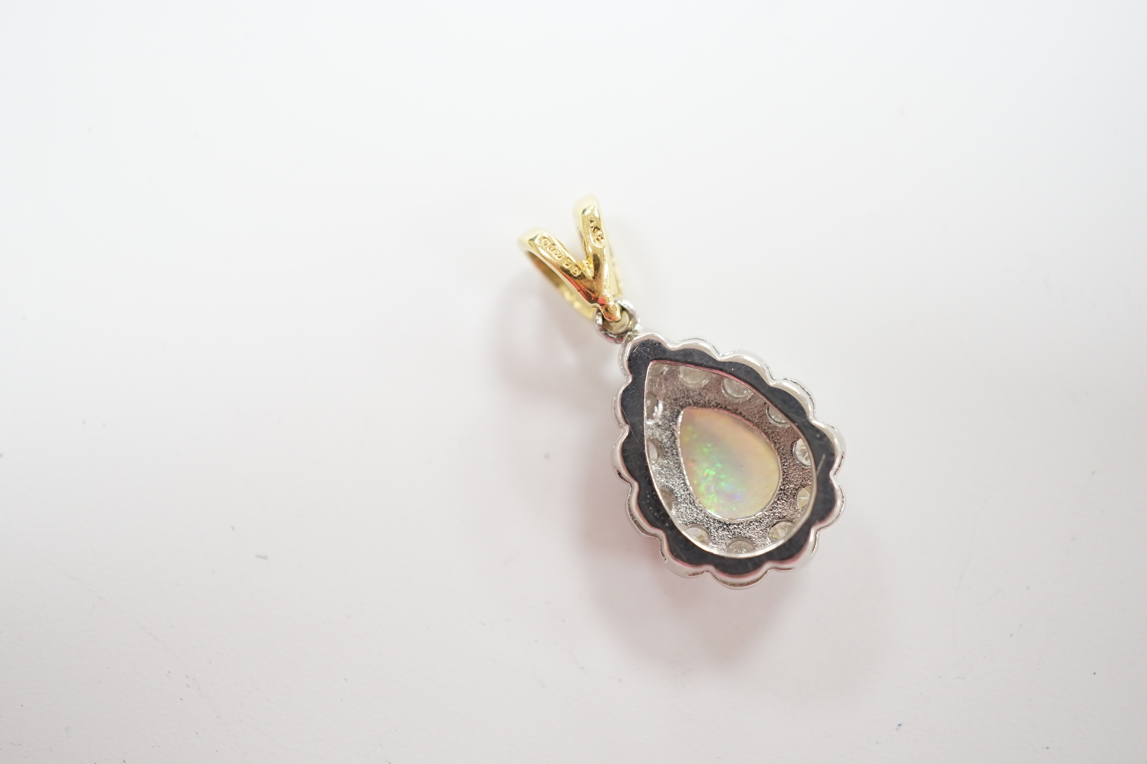 A modern 18ct gold, white opal and diamond set pear shaped cluster pendant, overall 23mm, gross weight 2.6 grams.